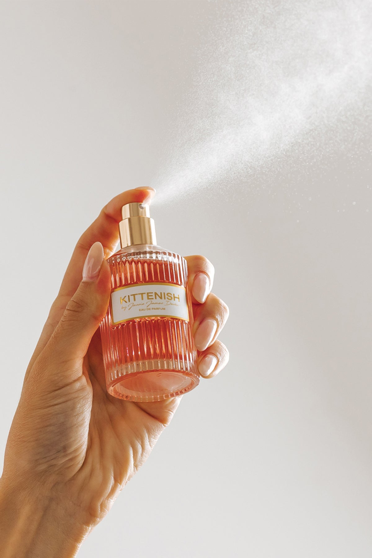 Kittenish perfume bottle being sprayed