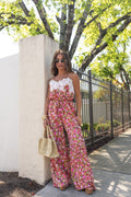 Jessie in a floral jumpsuit standing outdoors near a tree