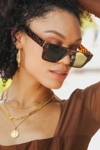 Model wearing the MK tortoise square frame sunglasses. 