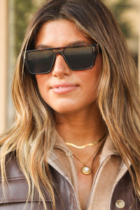 Model wearing The MK Tortoise square frame sunglasses.