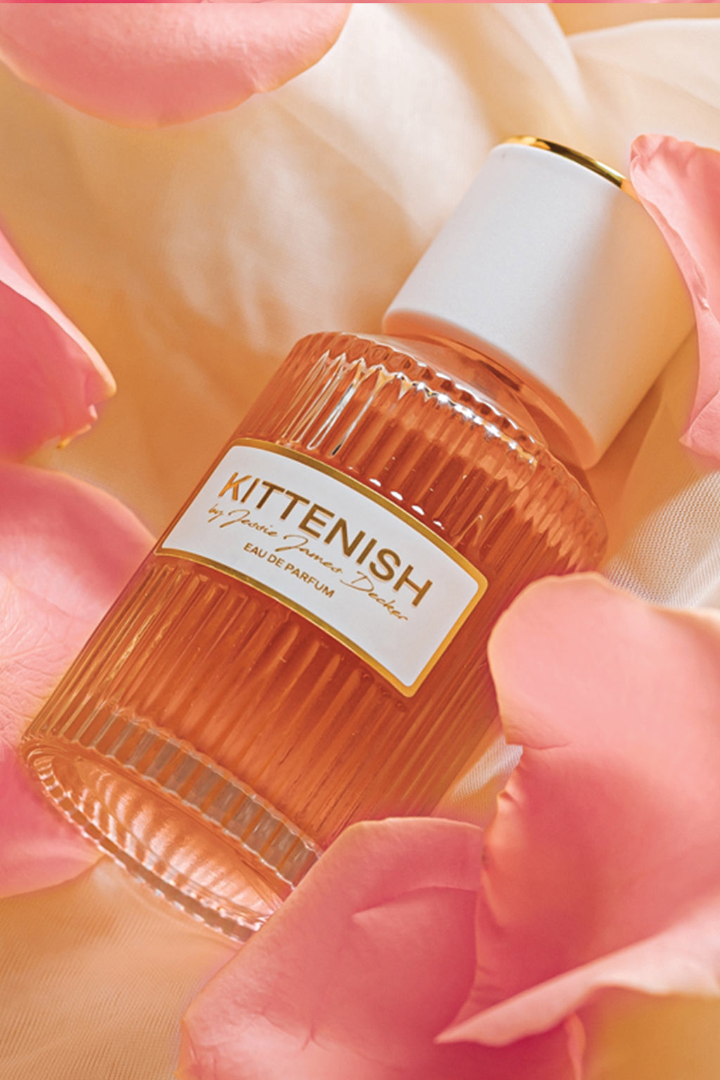 Kittenish perfume bottle laying in flower petals