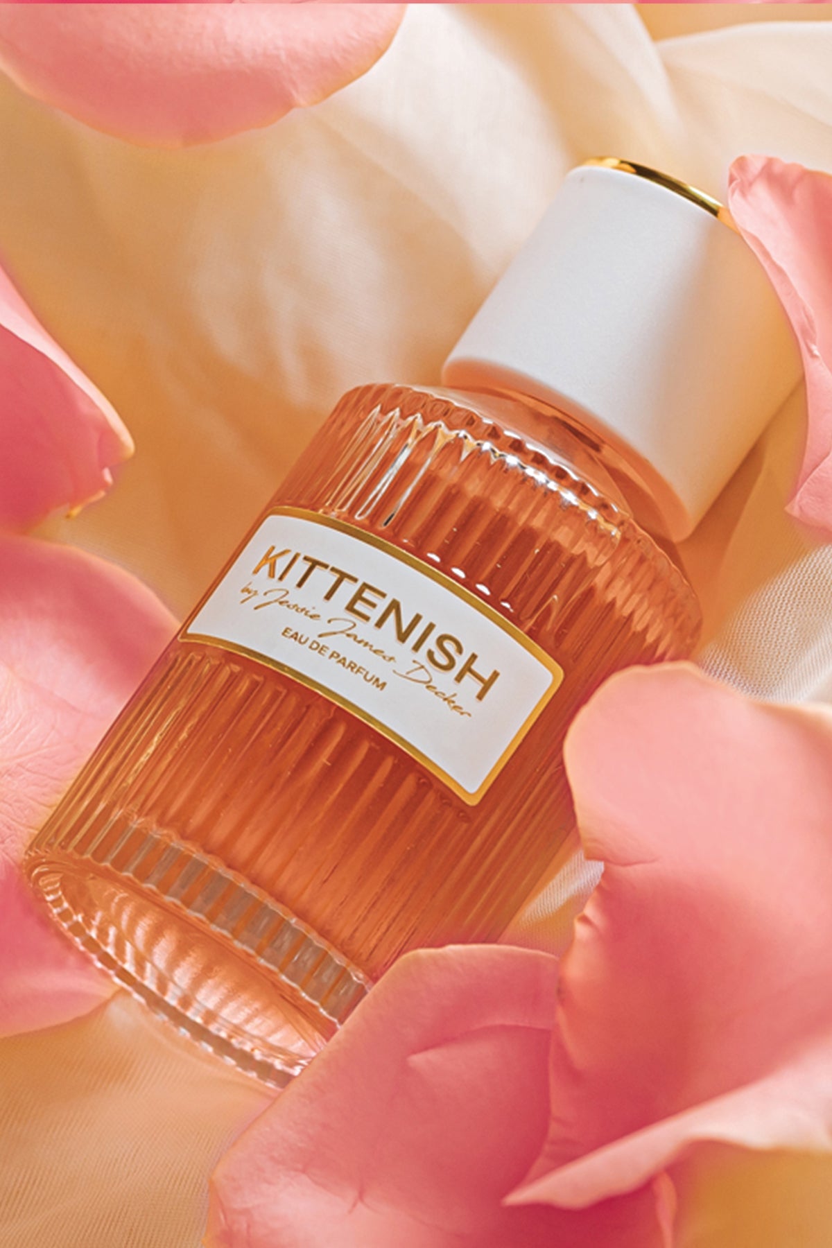 Kittenish perfume bottle laying in flower petals