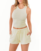 Model wearing a butter yellow tank and matching shorts with an adjustable drawstring on a white background
