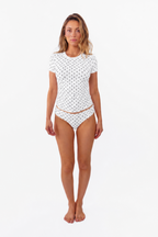 model wearing a white top and thong with black polka dots on a white backdrop
