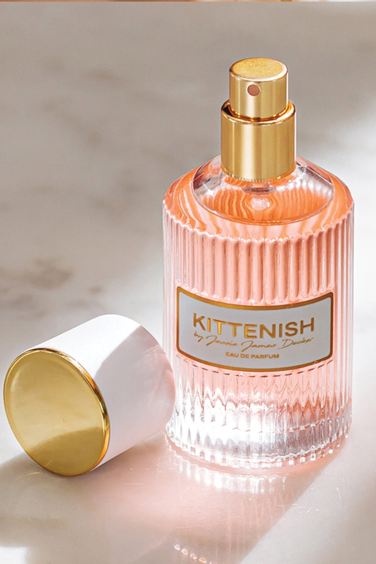 Kittenish perfume bottle on marble background