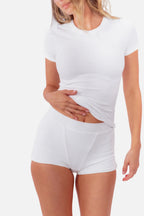 model wearing white ribbed boyshorts with matching tee standing in front of  a white backdrop