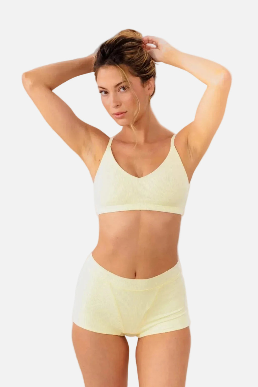A model wearing pale yellow high-waisted ribbed boyshorts and matching bralette
