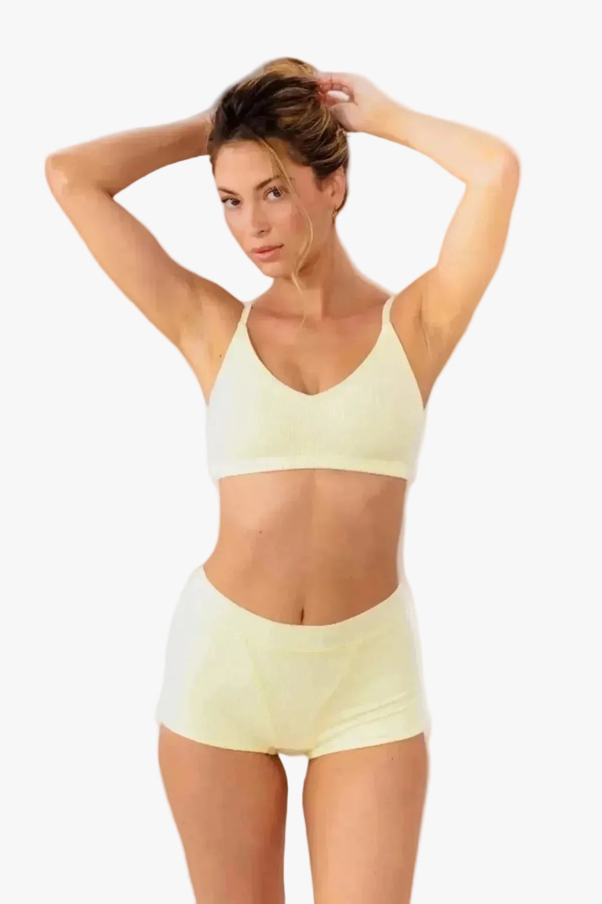 model wearing butter yellow boyshorts with matching bralette standing in front of a white backdrop