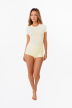 A model wearing pale yellow high-waisted ribbed boyshorts and matching tee