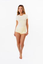 Model wearing a pale yellow short-sleeve shirt with matching shorts against a plain white background.
