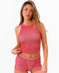 A woman modeling a two-piece red and white gingham set consisting of a sleeveless crop tank top and matching high-waisted boy shorts, standing against a plain white background.