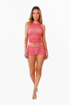 A woman modeling a two-piece red and white gingham set consisting of a sleeveless crop tank top and matching high-waisted boy shorts, standing against a plain white background.