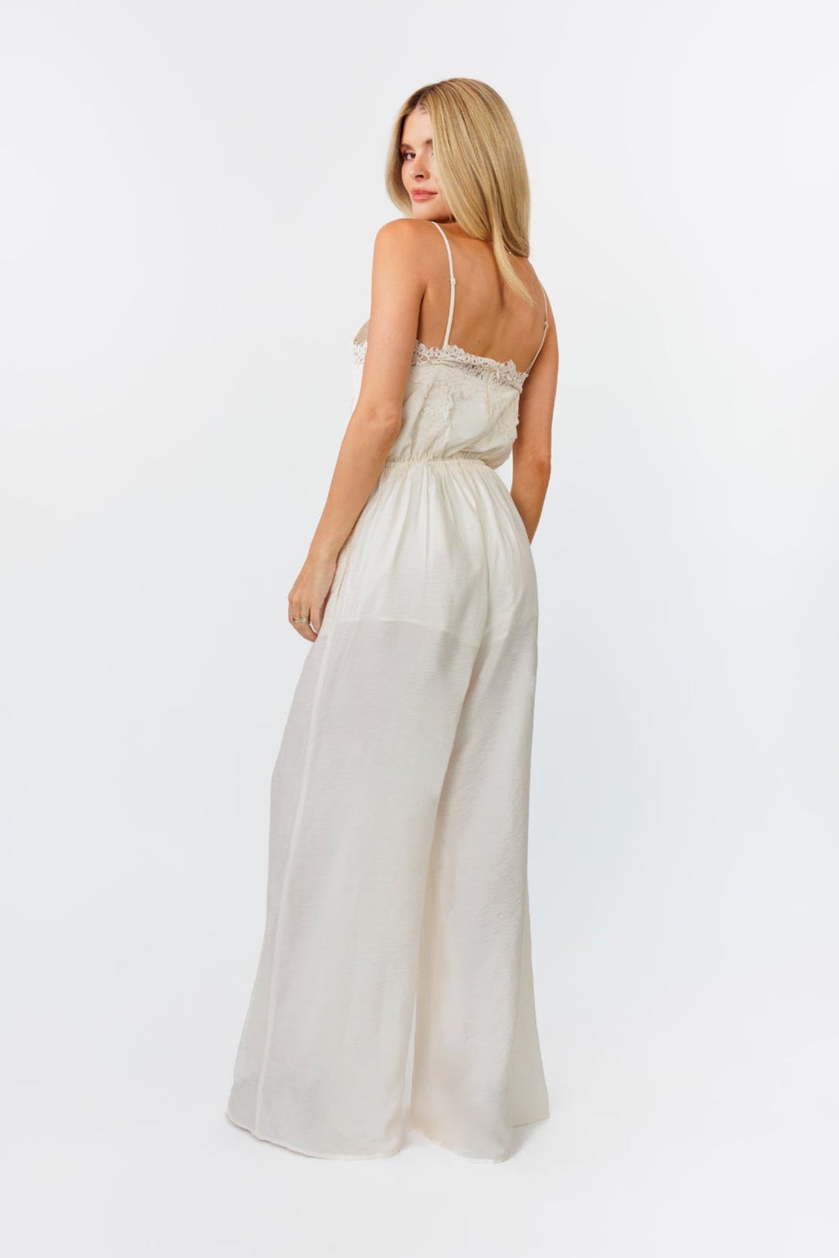 Woman wearing a white jumpsuit on a white background