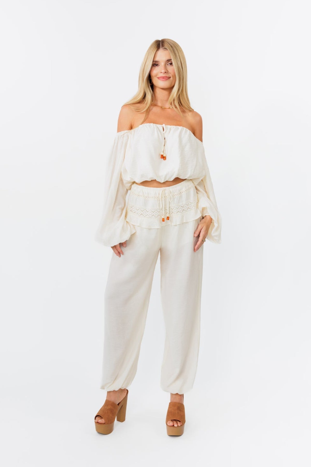 Woman wearing a white outfit with a plain background