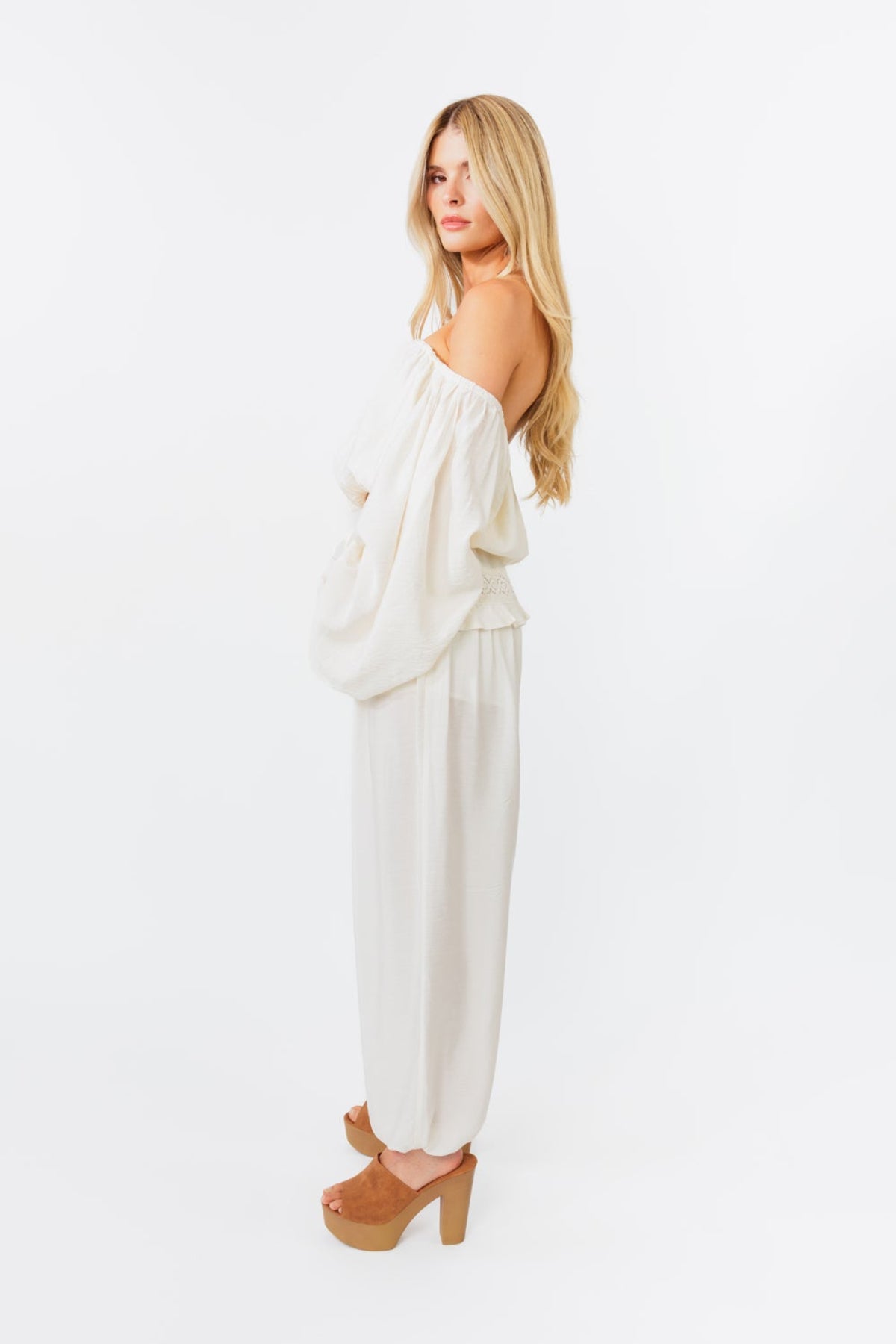 Woman wearing a white outfit with a plain background