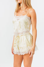 Woman wearing a light-colored lace outfit against a white background