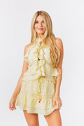 Woman wearing a yellow ruffled tank and skirt on a white background