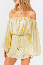 Woman wearing a light yellow off-shoulder top and skirt set on a white background