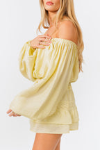 Woman wearing a light yellow off-shoulder top and skirt set on a white background