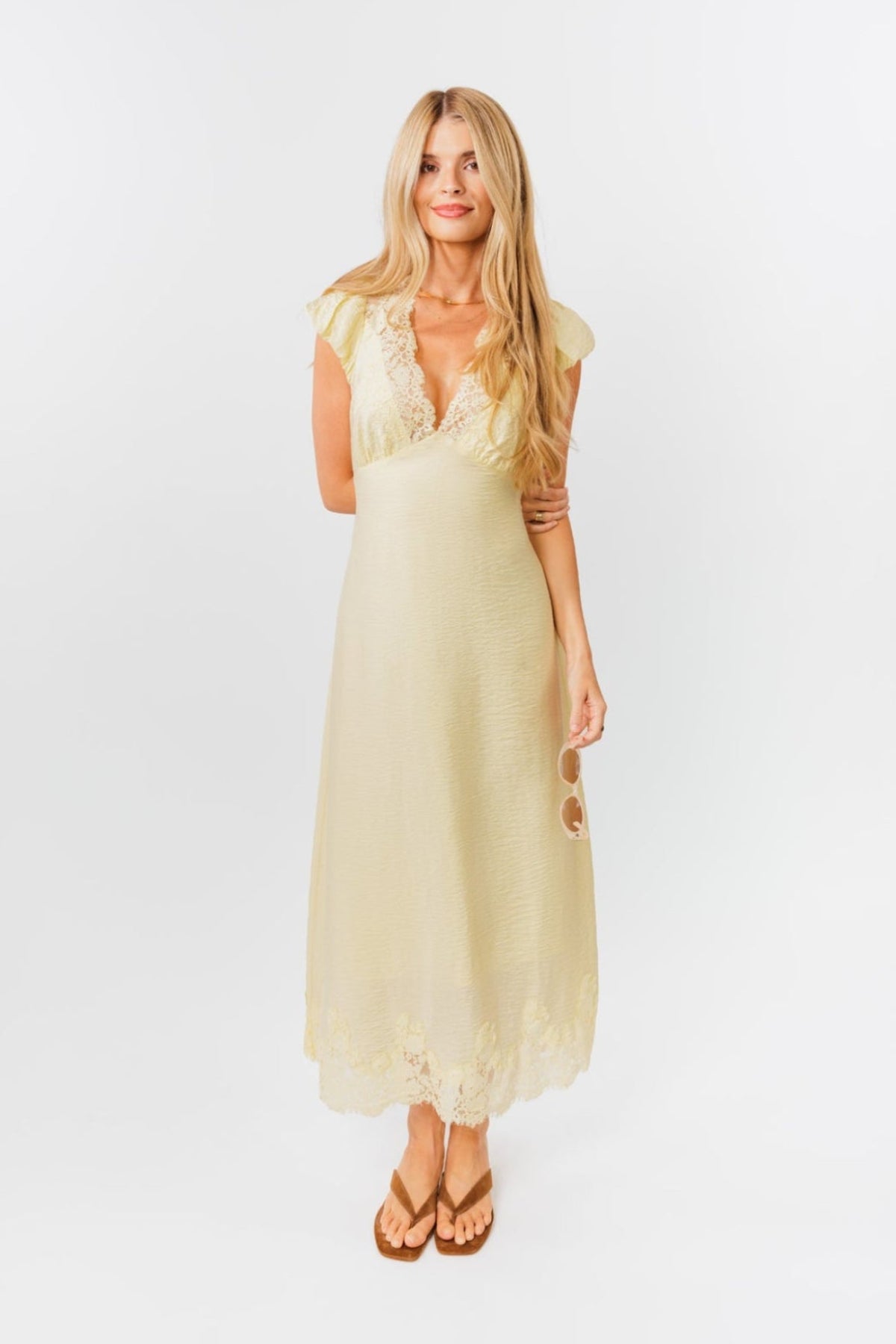 Woman wearing a light yellow dress on a white background