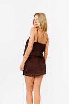 Woman wearing a brown set with thin straps on a white background