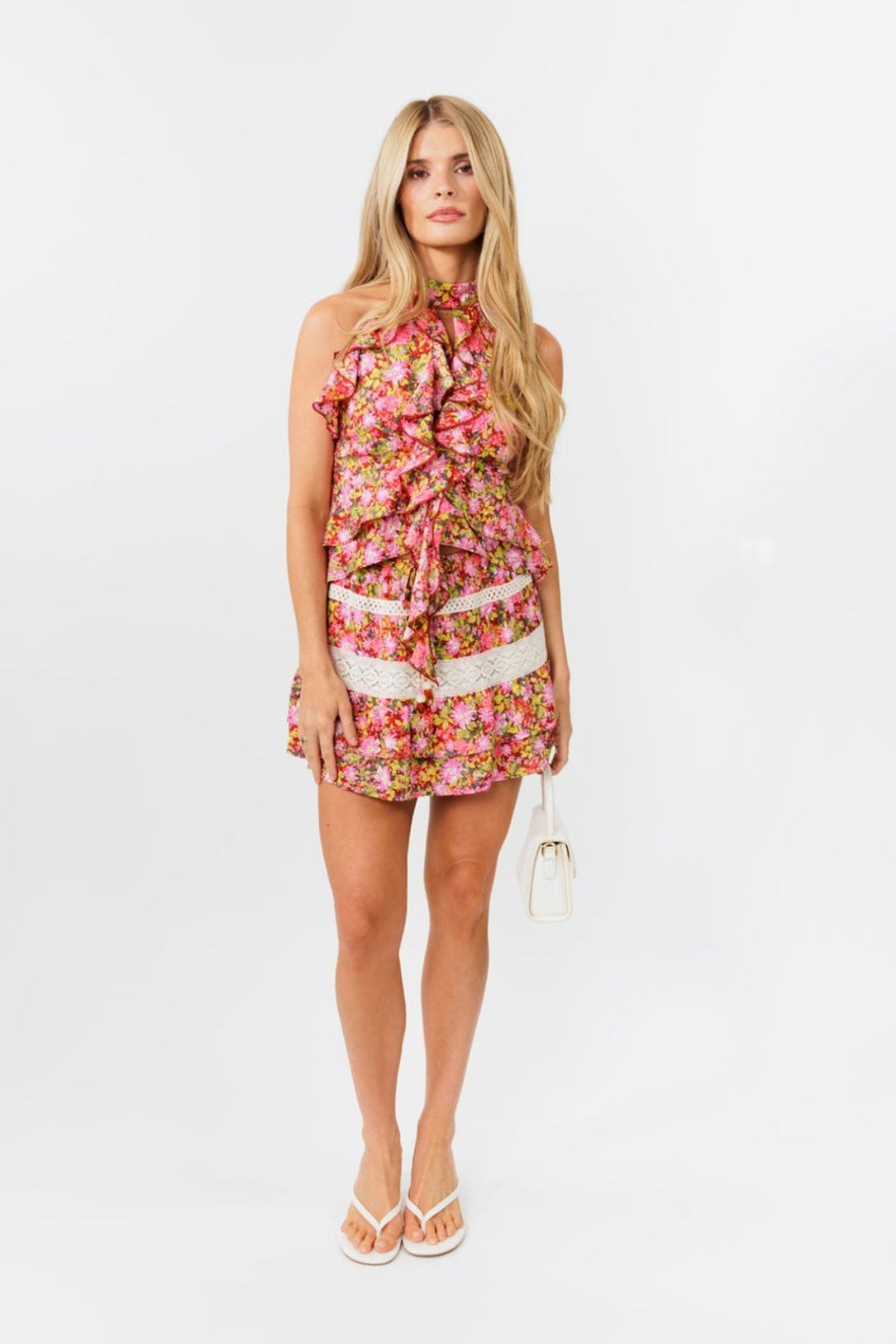 Woman wearing a floral skirt and top on a white background