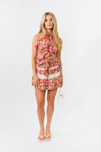 Woman wearing a floral skirt and top on a white background