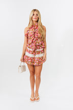 Woman wearing a floral skirt and top on a white background