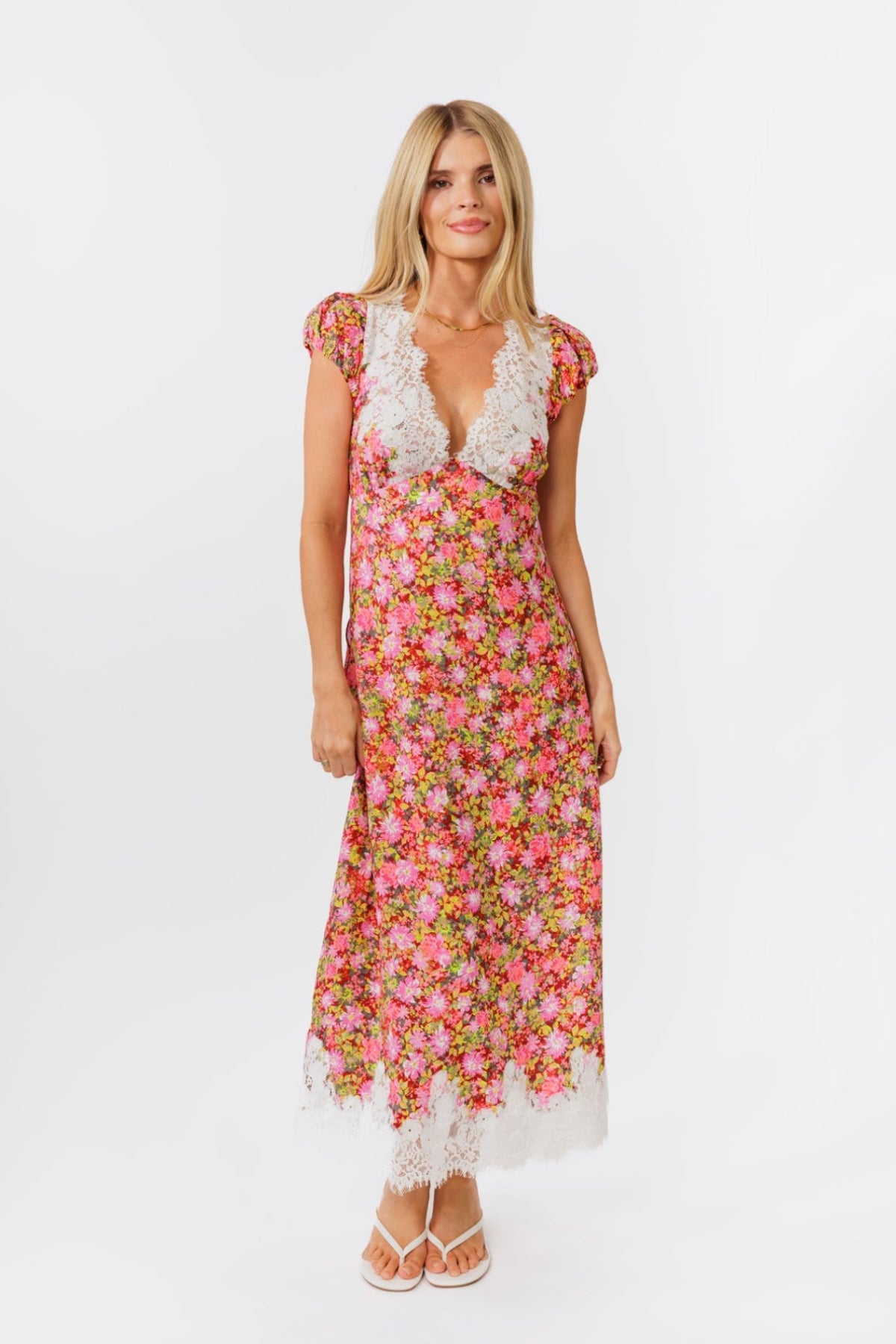 Woman wearing a floral dress with lace details on a white background