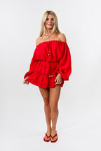 Woman wearing a red off-shoulder top and red skirt on a white background