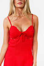 Red dress with thin straps worn by a model on a white background