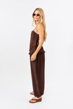 Woman wearing a brown tank and balloon  jogger pant on a white background