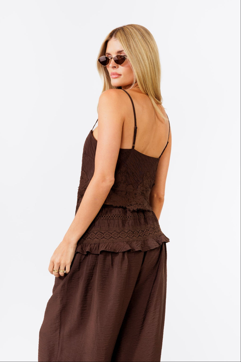 Woman wearing a brown tank and balloon  jogger pant on a white background