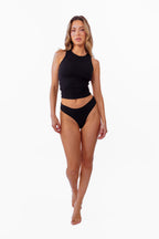 model wearing black ribbed tank with matching thong