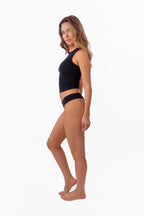 model wearing black ribbed tank with matching thong