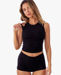 A model wearing black ribbed boyshorts and a matching tank against a plain white background.
