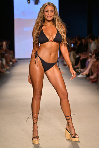 Model Tori Green wearing the Lucia Beaded side tie bikini bottom on the runway at Miami Swim Week