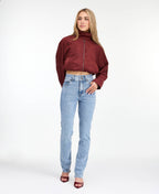 Model wearing high waisted skinny straight leg jeans with a studded waistband paired with kitten heels.