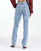 Model wearing high waisted skinny straight leg jeans with a studded waistband paired with kitten heels.