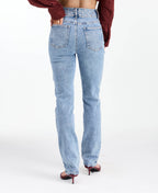 Model wearing high waisted skinny straight leg jeans with a studded waistband paired with kitten heels.