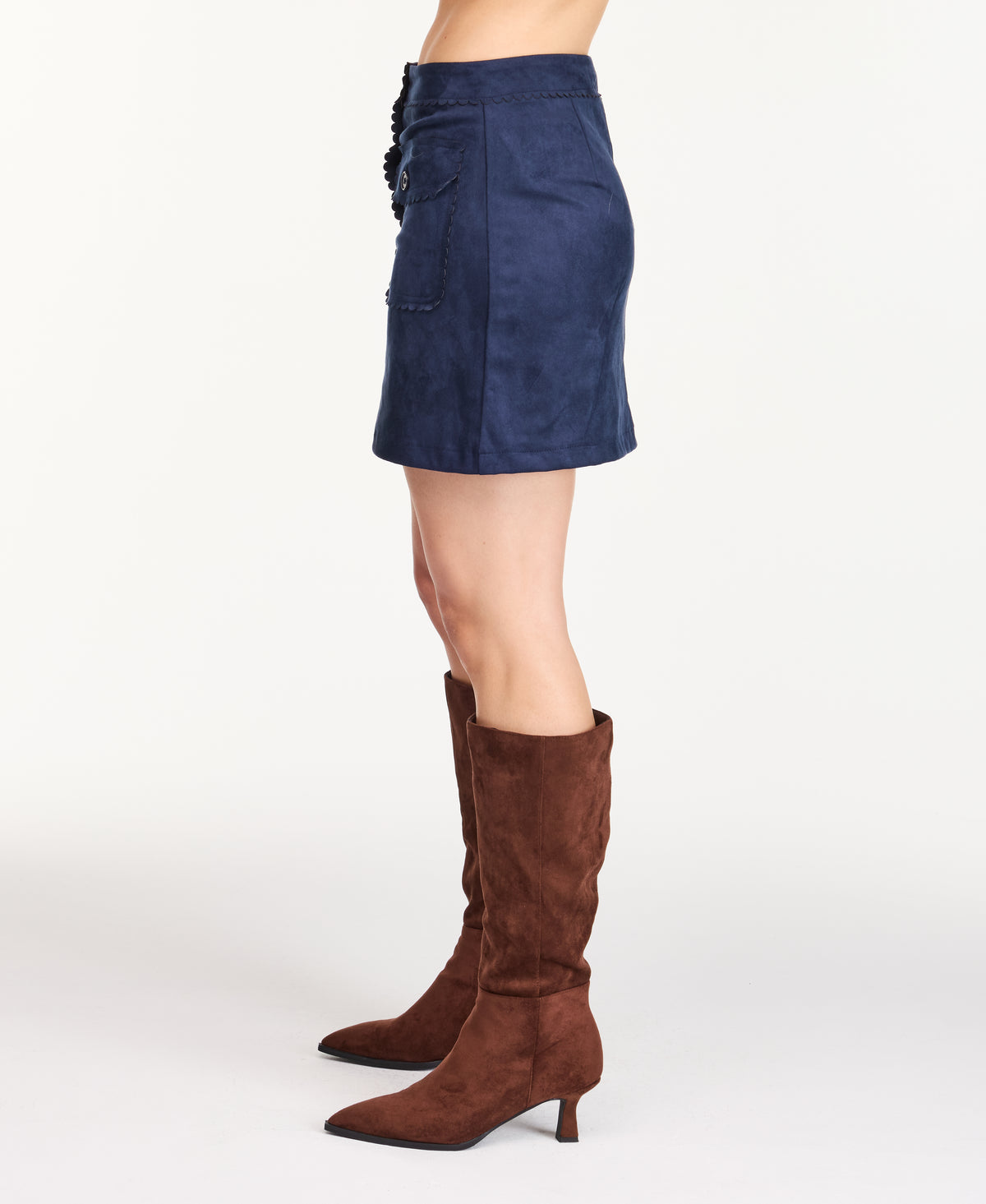 Model wearing navy blue faux suede skirt with a flannel shacket, brown boots, and a white tee