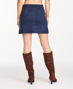 Model wearing navy blue faux suede skirt with a flannel shacket, brown boots, and a white tee