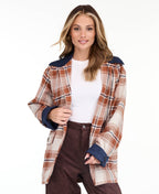 Model wearing a light brown plaid coat with navy blue contrast lapels and cuffs, styled over a white top and brown pants against a plain white background.