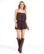 A model from the waist down wearing dark brown shorts with a white polka dot pattern against a plain white studio background.