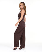 A woman modeling a dark brown pinstriped sleeveless vest-style top and barrel pants, standing against a plain white studio background.