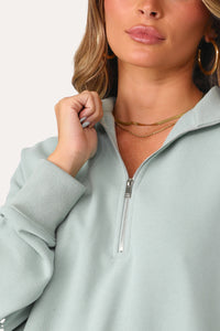 Model wearing Bubbly Blue Half Zip Logo Pullover.