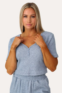 Model wearing the Self Care blue short sleeve henley.