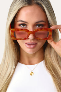 Model wearing the Regina Phalange orange tortoise sunglasses.