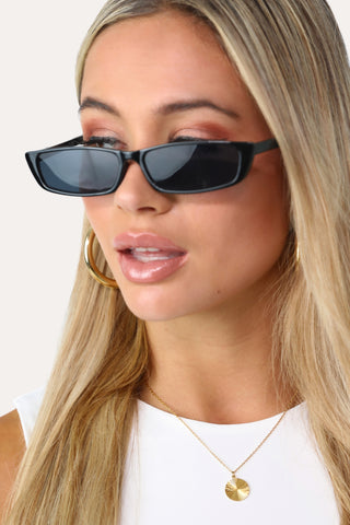 Model wearing the Carrie  thin black sunglasses.