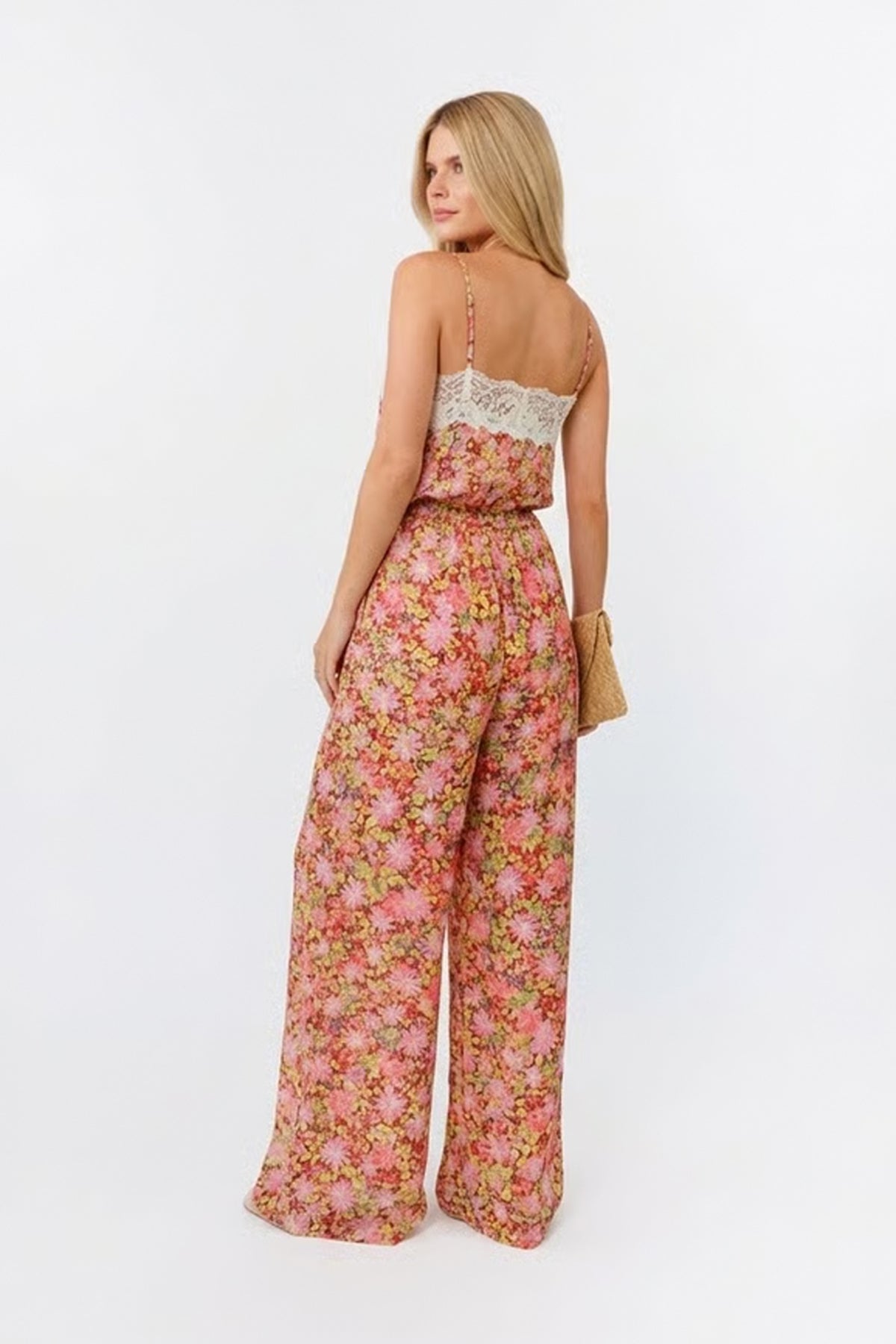 Woman wearing a floral jumpsuit on a white background